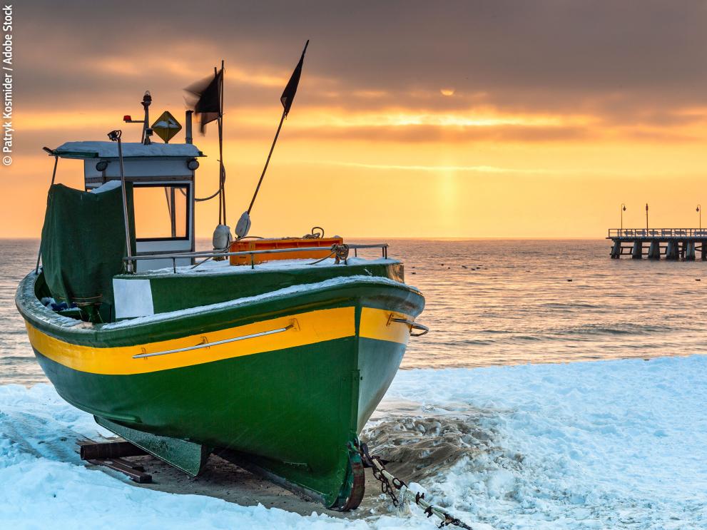 Fishing boat on snowy beach in Gdynia Orlowo at sunrise, Baltic Sea. Poland. © Patryk Kosmider / Adobe Stock